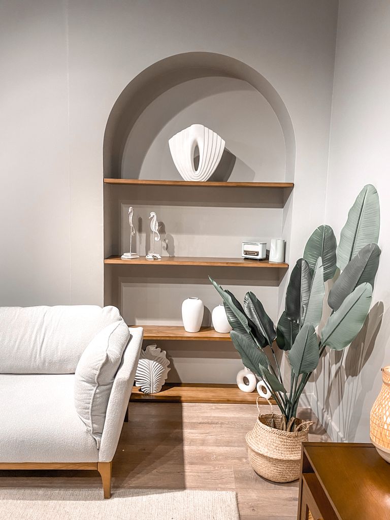Elegant living room featuring modern decor, arch shelves, and cozy furniture.