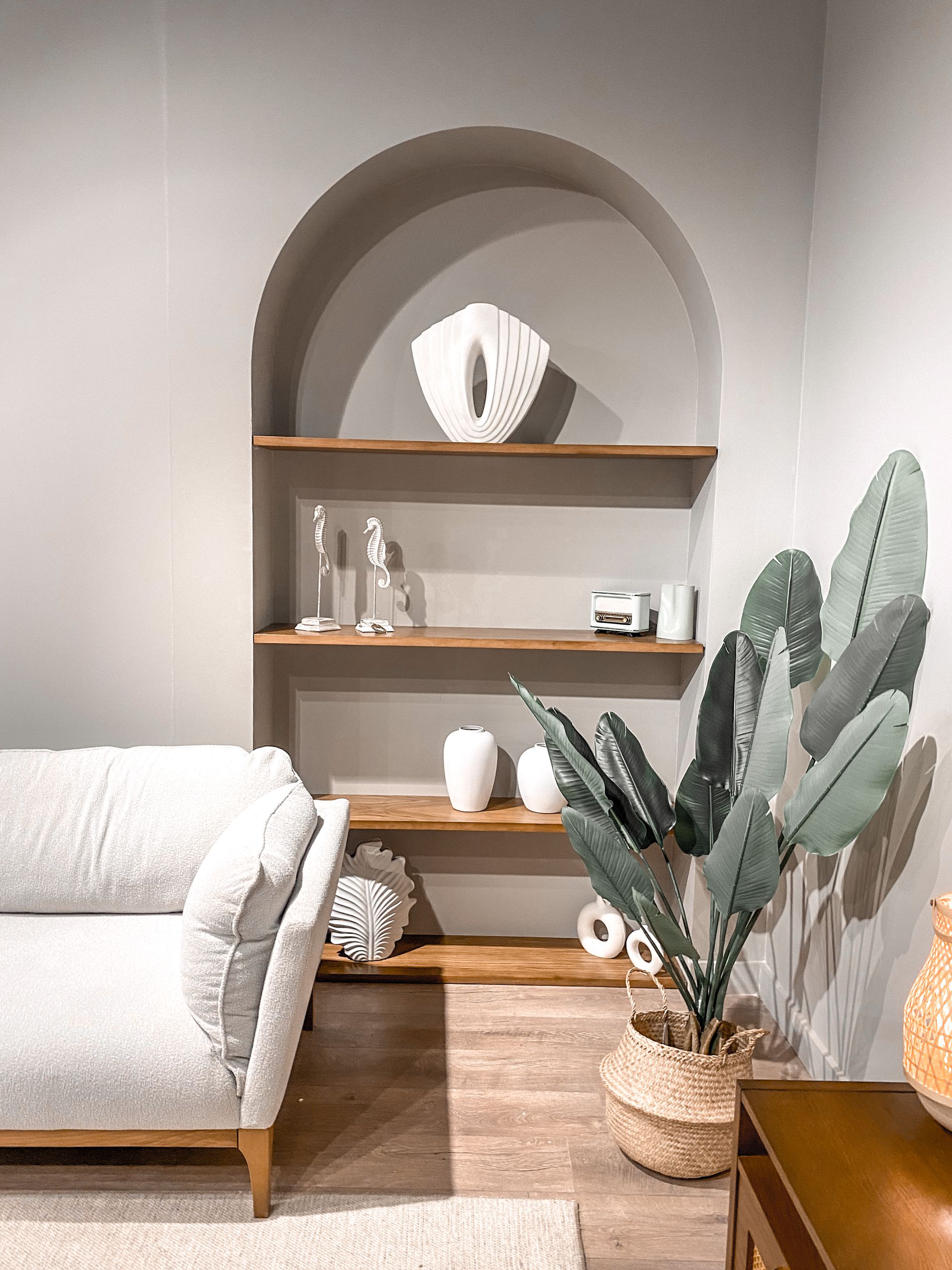 Elegant living room featuring modern decor, arch shelves, and cozy furniture.